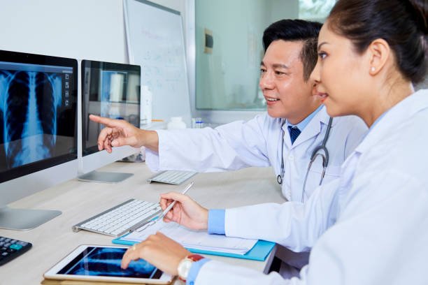 Radiologists reviewing chest X-ray images on computer screens together